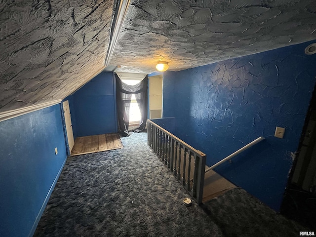 additional living space with vaulted ceiling, carpet, and a textured ceiling