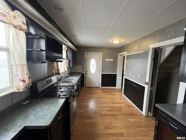 kitchen with gas range, extractor fan, sink, and light wood-type flooring