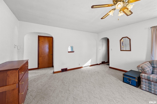 living area with light colored carpet and ceiling fan