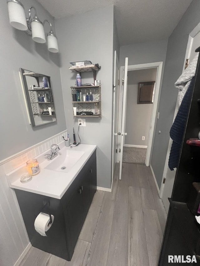 bathroom featuring wood-type flooring, a textured ceiling, and vanity