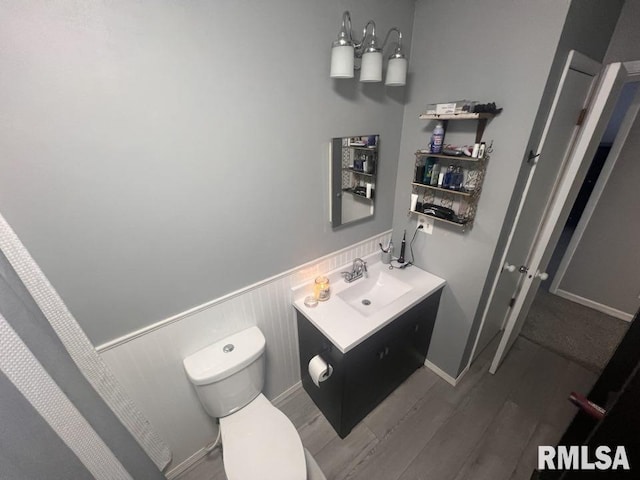 bathroom featuring wood-type flooring, vanity, and toilet