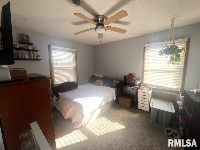 carpeted bedroom featuring multiple windows and ceiling fan