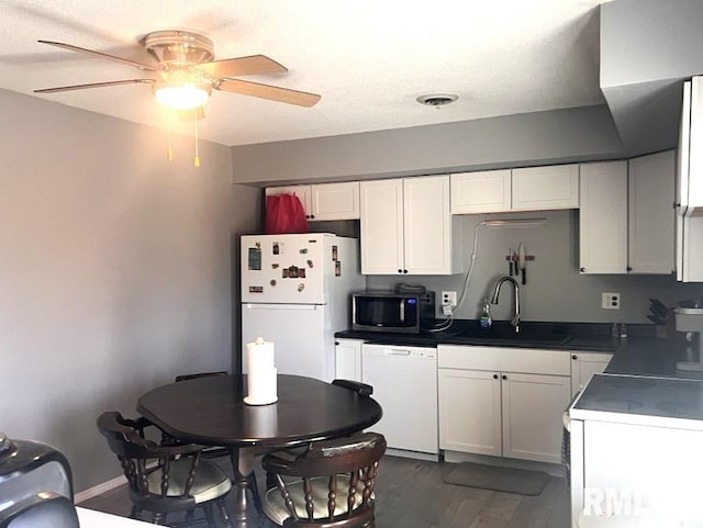 kitchen with sink, white cabinets, dark hardwood / wood-style flooring, ceiling fan, and white appliances