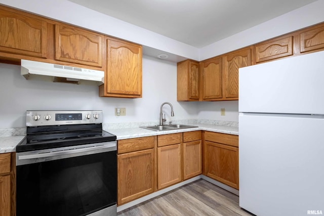 kitchen featuring white refrigerator, stainless steel electric stove, sink, and light hardwood / wood-style flooring