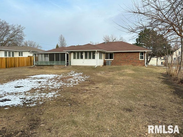 rear view of house with a yard and a sunroom