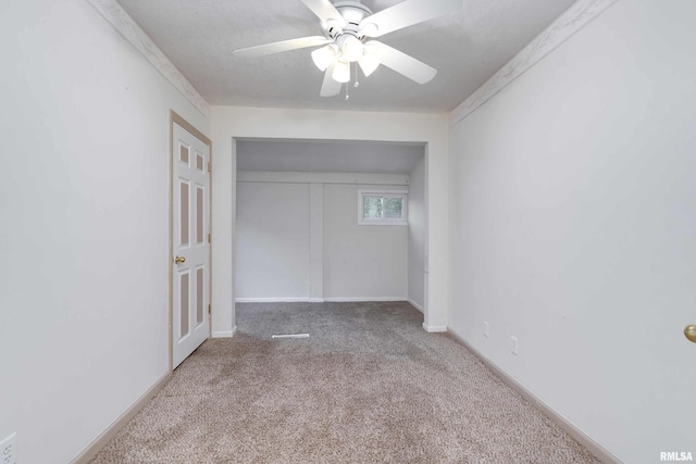 unfurnished bedroom featuring light carpet, a closet, and ceiling fan