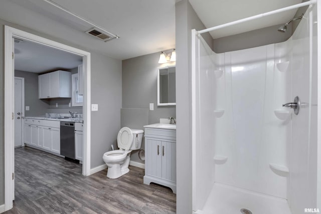 bathroom featuring vanity, wood-type flooring, toilet, and walk in shower