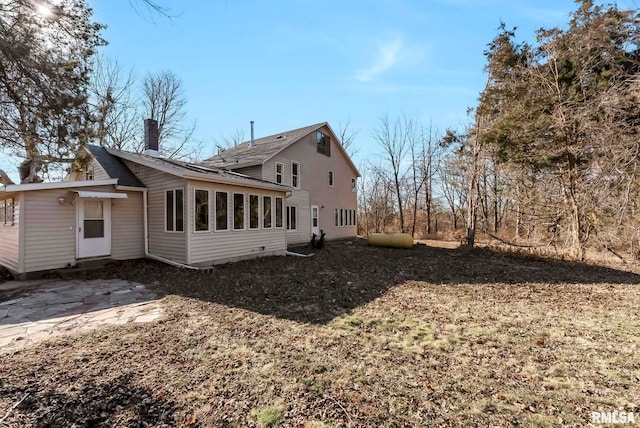 rear view of house featuring a patio area and a sunroom