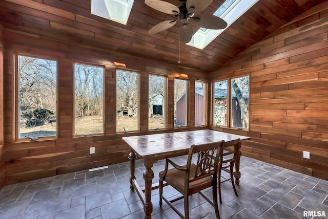 sunroom with wood ceiling, ceiling fan, a healthy amount of sunlight, and vaulted ceiling with skylight