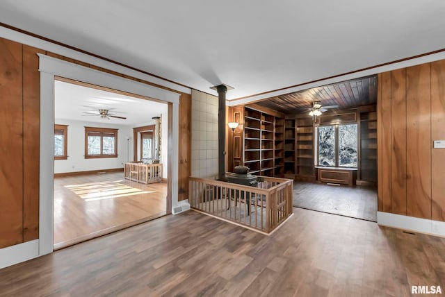 interior space with hardwood / wood-style flooring, ceiling fan, crown molding, and built in features