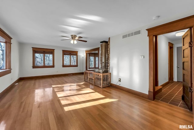 unfurnished living room featuring ceiling fan, a healthy amount of sunlight, and hardwood / wood-style floors