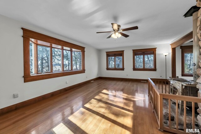 unfurnished living room featuring ceiling fan and dark hardwood / wood-style flooring