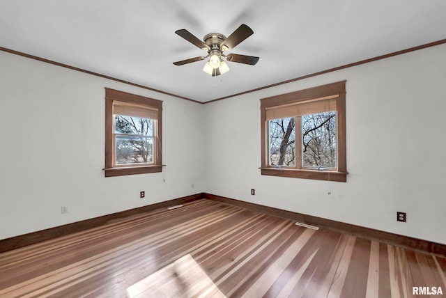 empty room with crown molding, ceiling fan, and plenty of natural light