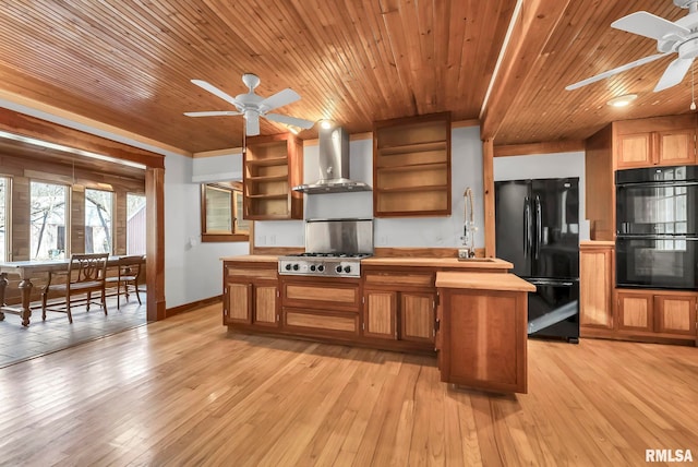 kitchen with wood ceiling, ceiling fan, black appliances, wall chimney exhaust hood, and light wood-type flooring