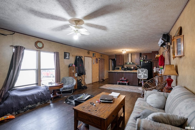 living room featuring ceiling fan, a textured ceiling, and dark hardwood / wood-style flooring