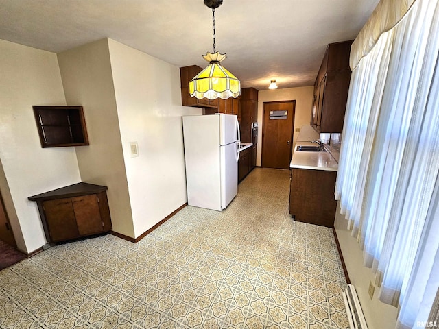 kitchen featuring white fridge, sink, and decorative light fixtures