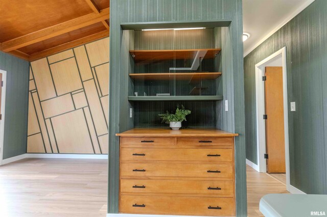 unfurnished bedroom featuring baseboard heating, dark carpet, a closet, and beamed ceiling