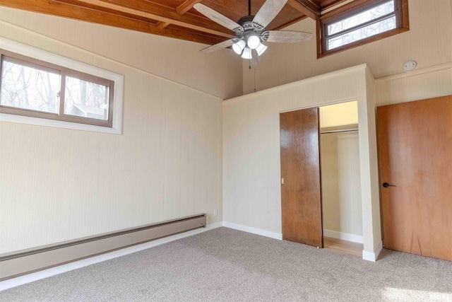 unfurnished bedroom with lofted ceiling, a baseboard radiator, a closet, and carpet flooring