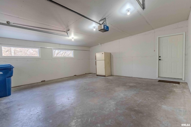 garage featuring a garage door opener and white refrigerator