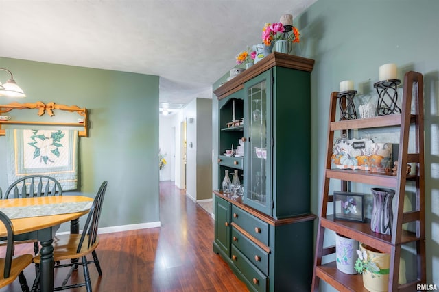 dining area with baseboards and dark wood-type flooring