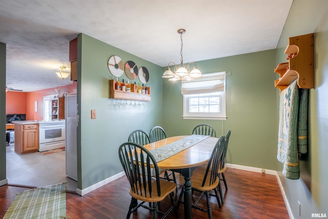 dining area featuring a notable chandelier, wood finished floors, and baseboards