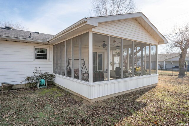 back of property with a sunroom and roof with shingles