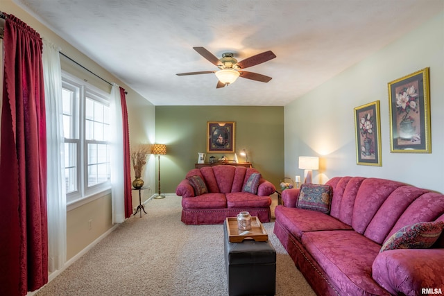 carpeted living area featuring baseboards and a ceiling fan