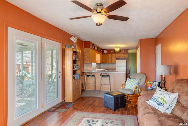 living room featuring wooden walls, light wood-type flooring, and a ceiling fan