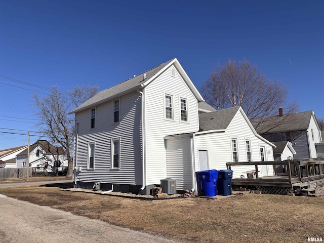 view of home's exterior featuring central AC, a deck, and a lawn