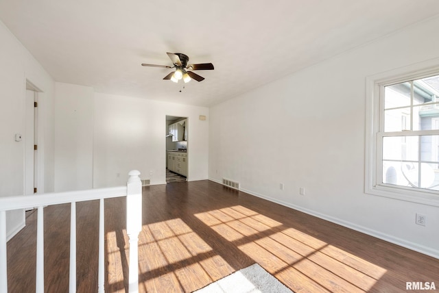 unfurnished room with dark wood-type flooring and ceiling fan