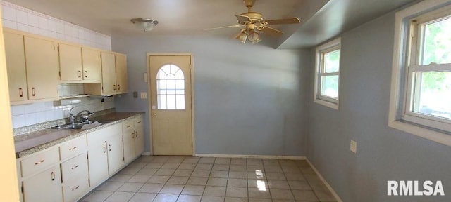 kitchen featuring tasteful backsplash, sink, a wealth of natural light, and light tile patterned flooring