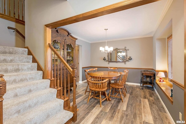 dining room with an inviting chandelier, hardwood / wood-style floors, and ornamental molding