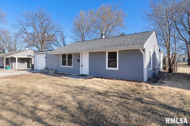 ranch-style home with a garage, a shingled roof, a front yard, and fence