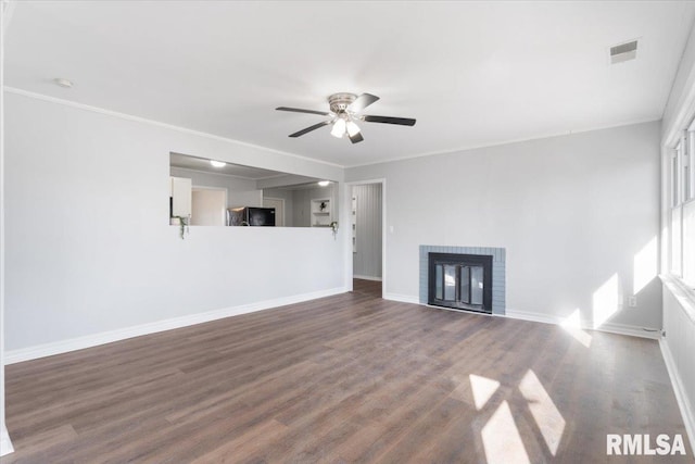 unfurnished living room featuring ornamental molding, dark wood-style flooring, visible vents, and a fireplace