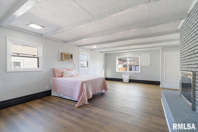 bedroom featuring baseboards, beamed ceiling, wood finished floors, and a wall mounted AC