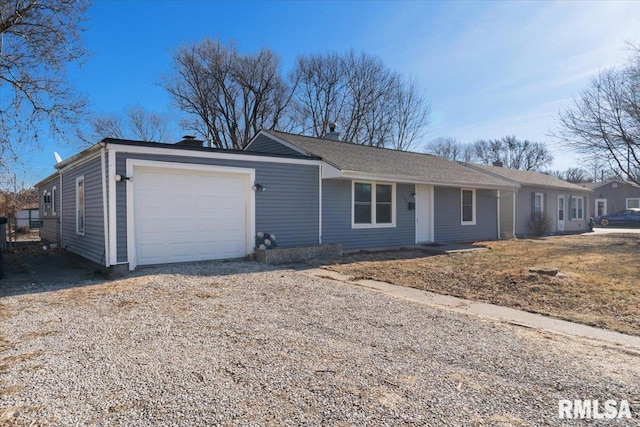 ranch-style home featuring an attached garage and gravel driveway