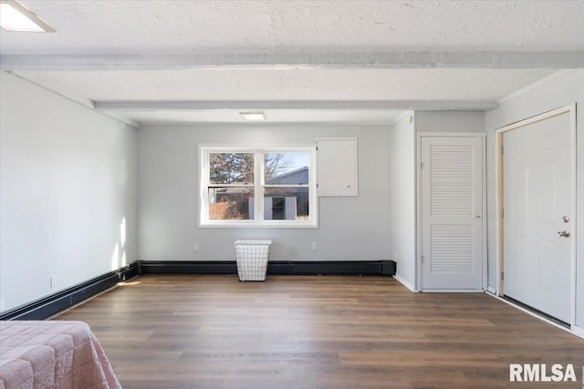 unfurnished bedroom with a textured ceiling, a baseboard radiator, wood finished floors, baseboards, and beam ceiling