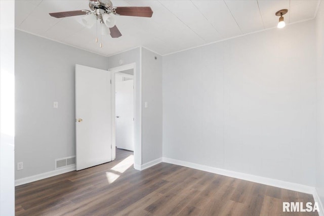 spare room with visible vents, crown molding, baseboards, and wood finished floors