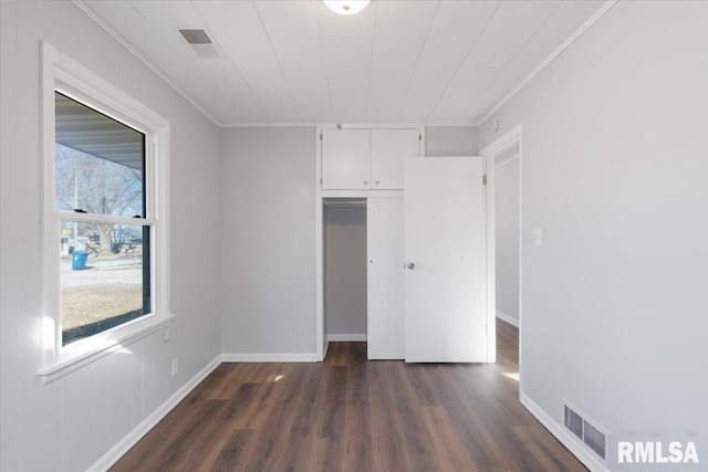 unfurnished bedroom featuring dark wood-type flooring, visible vents, and ornamental molding