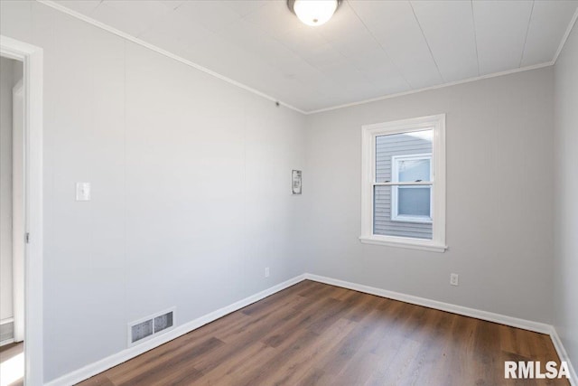 spare room with ornamental molding, dark wood-type flooring, visible vents, and baseboards