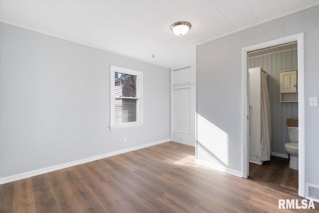 unfurnished bedroom featuring ornamental molding, wood finished floors, visible vents, and baseboards