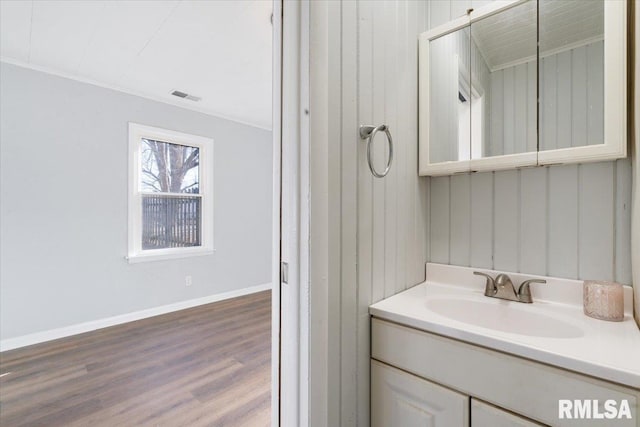 bathroom with vanity, wood finished floors, visible vents, and baseboards