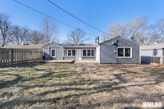 back of property with a yard, a patio area, fence, and a chimney