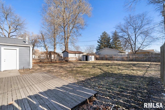 view of yard featuring a storage shed, a deck, an outdoor structure, and fence