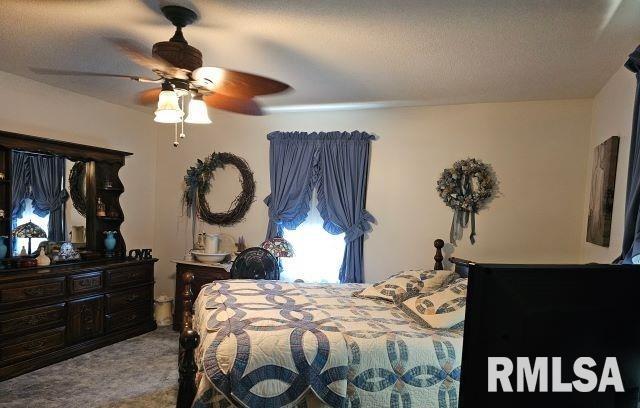 carpeted bedroom featuring a textured ceiling and ceiling fan