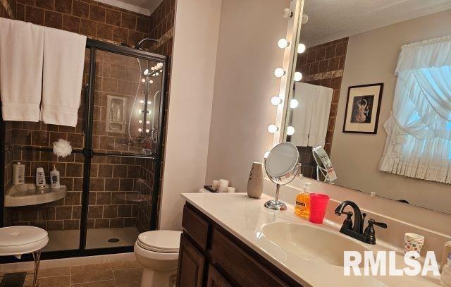 bathroom with walk in shower, tile patterned floors, vanity, and toilet