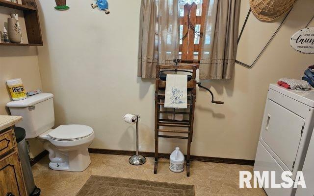 bathroom with vanity, toilet, and washer / dryer