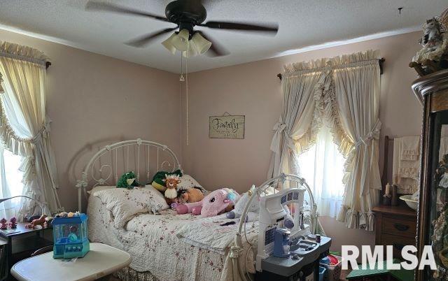 bedroom with ceiling fan and a textured ceiling