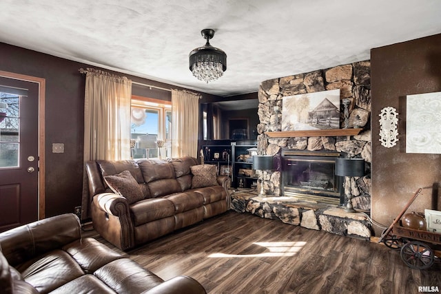 living room with a fireplace, a notable chandelier, and wood-type flooring