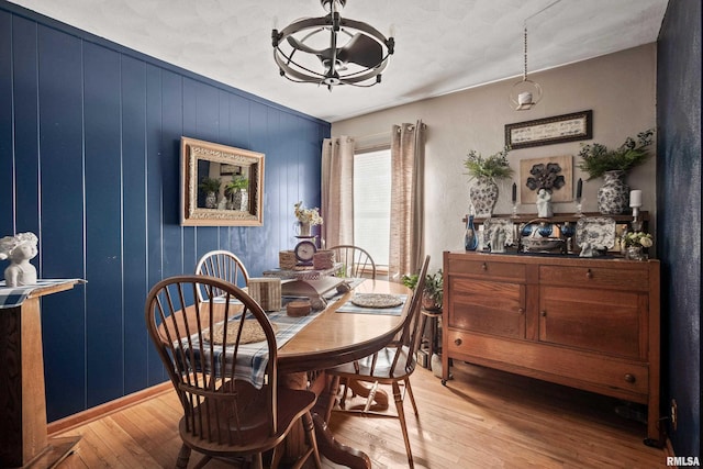 dining room with wooden walls and light wood-type flooring